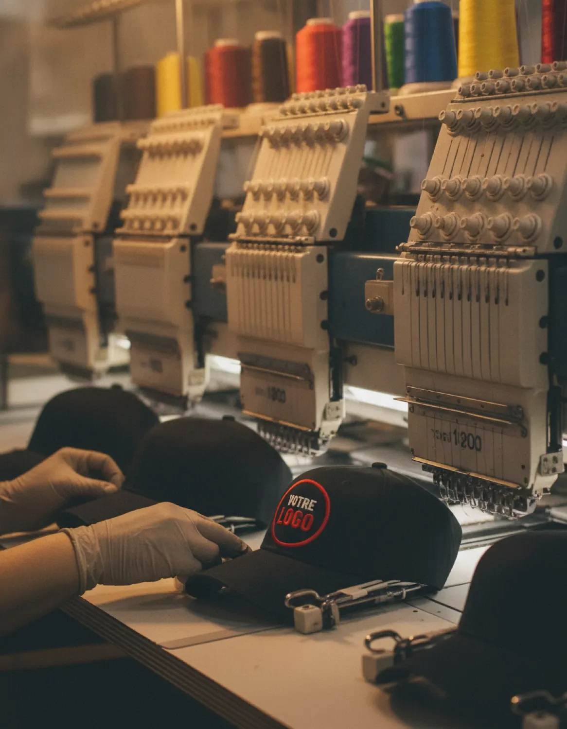 Machine à broder multi-têtes, casquette en cours de broderie